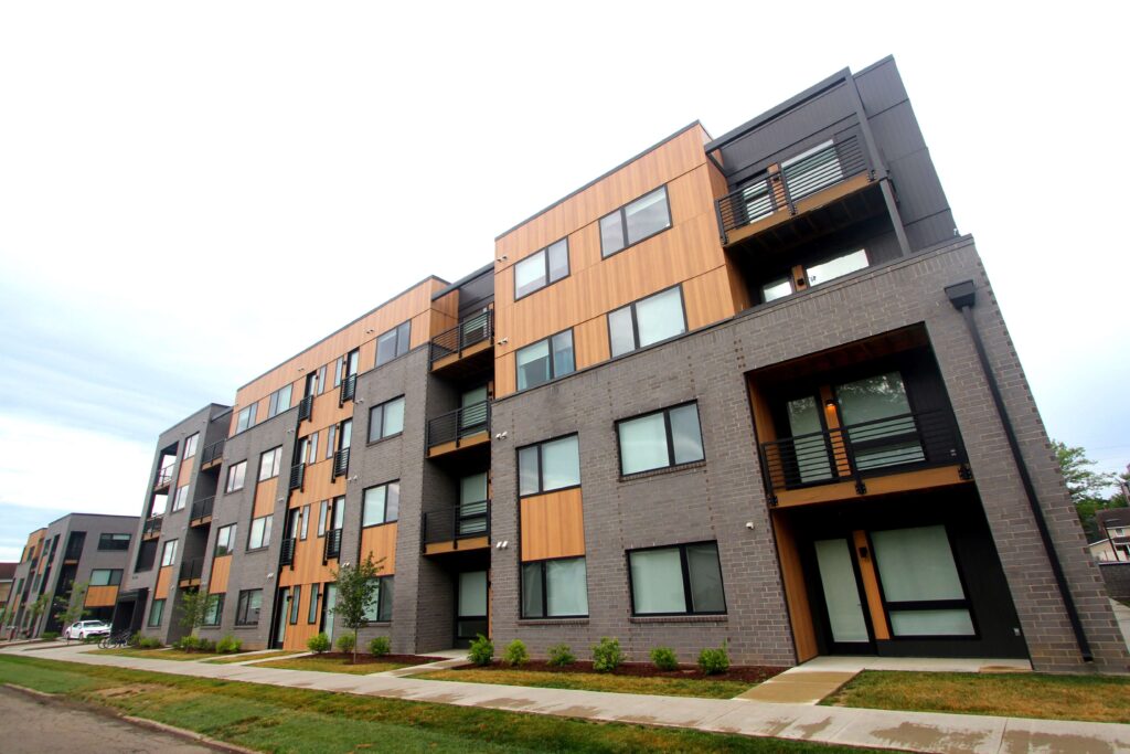 Modern multi-family residential building featuring wood-panel siding and grey brick masonry, demonstrating expert building restoration Indianapolis craftsmanship.
