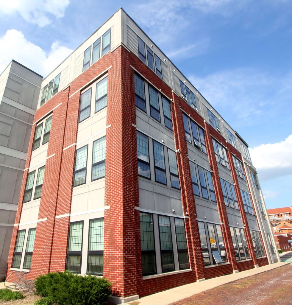 Professionally restored red brick pillars and facade on a modern Indianapolis commercial building, demonstrating top-rated brick repair by Emerson Masonry Inc.
