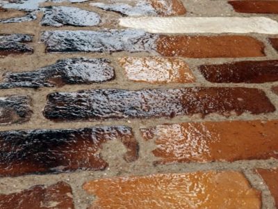 Close-up of multi-colored brick pavers with a high-gloss waterproof sealant protecting against moisture.