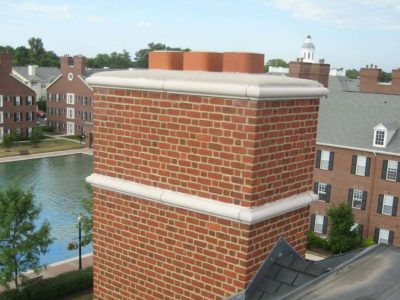 Professional brick chimney masonry restoration with precision tuckpointing and new concrete cap.